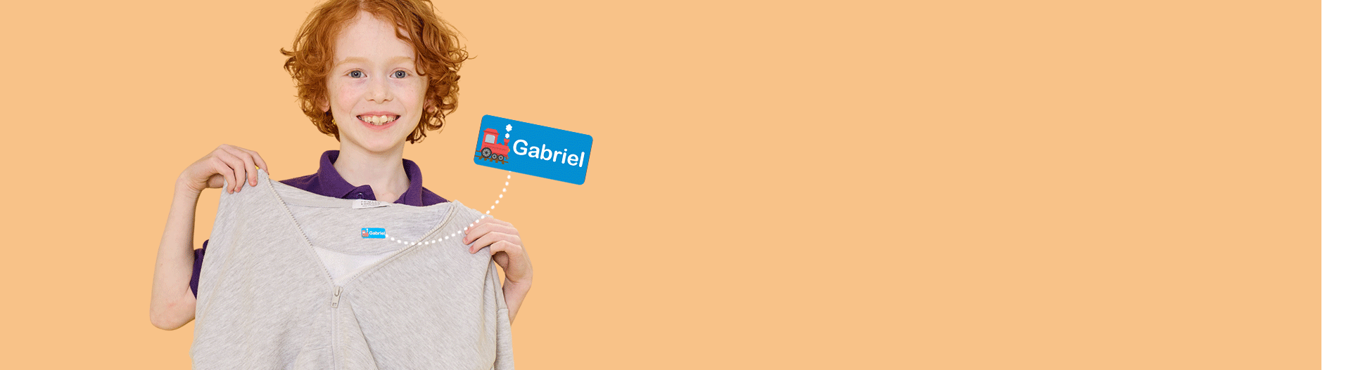 Child holding clothing with a personalised name label