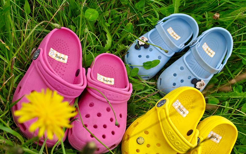 Sustainable name stickers from My Nametags on crocs in green grass