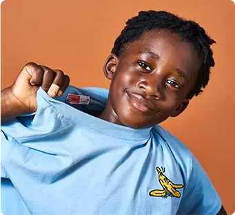 Boy holding up t-shirt identified by the sticker name label on the collar