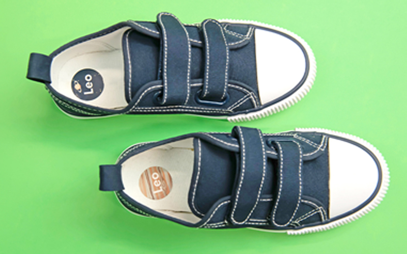 Cute white children's trainers with shoe name stickers from My Nametags on a pink backround